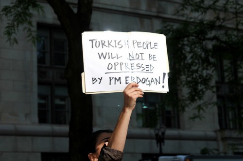 A protester holding a sign expressing opposition against Turkish PM Erdogan