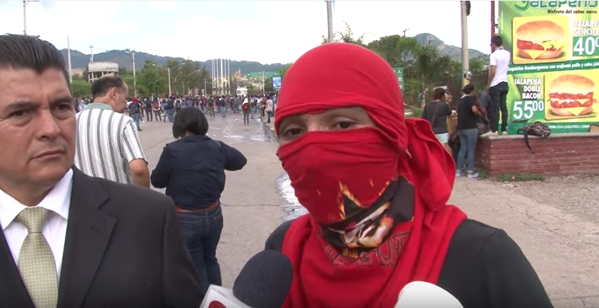 UNAH student activists cover their faces to avoid arrest. Image via Youtube user: Canal 11 - Honduras.